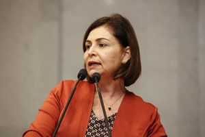 Foto da deputada Simone Santana falando ao microfone na tribuna do Plenário.