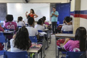 Foto de crianças assistindo aula com intérprete de Libras na Escola Estadual Governador Barbosa Lima.