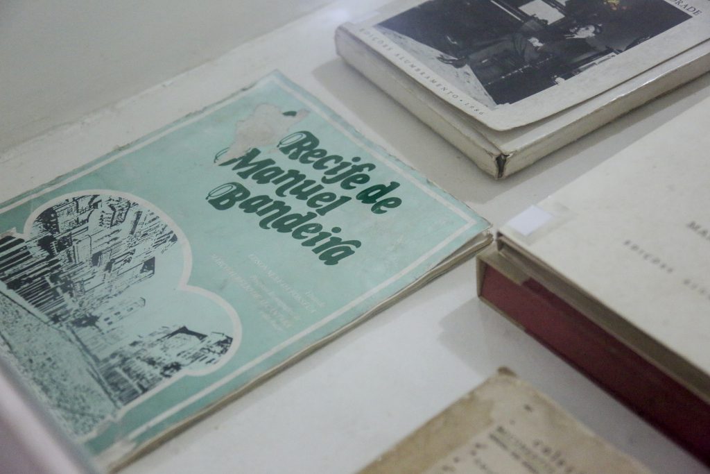 Foto de livros do acervo do Espaço Pasárgada, com destaque para "Recife de Manuel Bandeira".