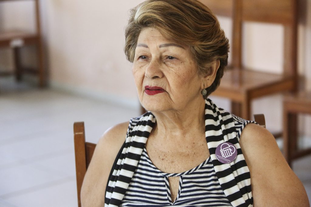Foto da presidente da Abraz-PE, Cleonice Albuquerque, sentada numa cadeira.