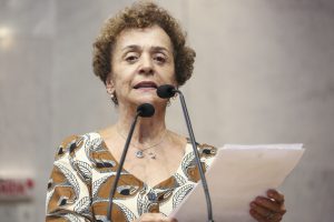 Foto da deputada Laura Gomes falando ao microfone na tribuna.