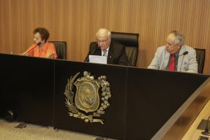 Foto dos deputados Laura Gomes, Zé Maurício e José Humberto Cavalcanti sentado à mesa do Plenarinho.