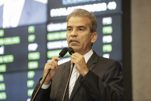 Foto de Alberto Feitosa falando ao microfone.