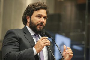 Foto do deputado Rodrigo Novaes falando ao microfone do Plenário da Alepe.