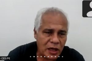 Homem pardo, de cabelos grisalhos, fala em reunião online