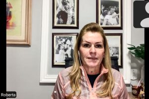 Deputada em reunião online, com fotografias familiares emolduradas ao fundo