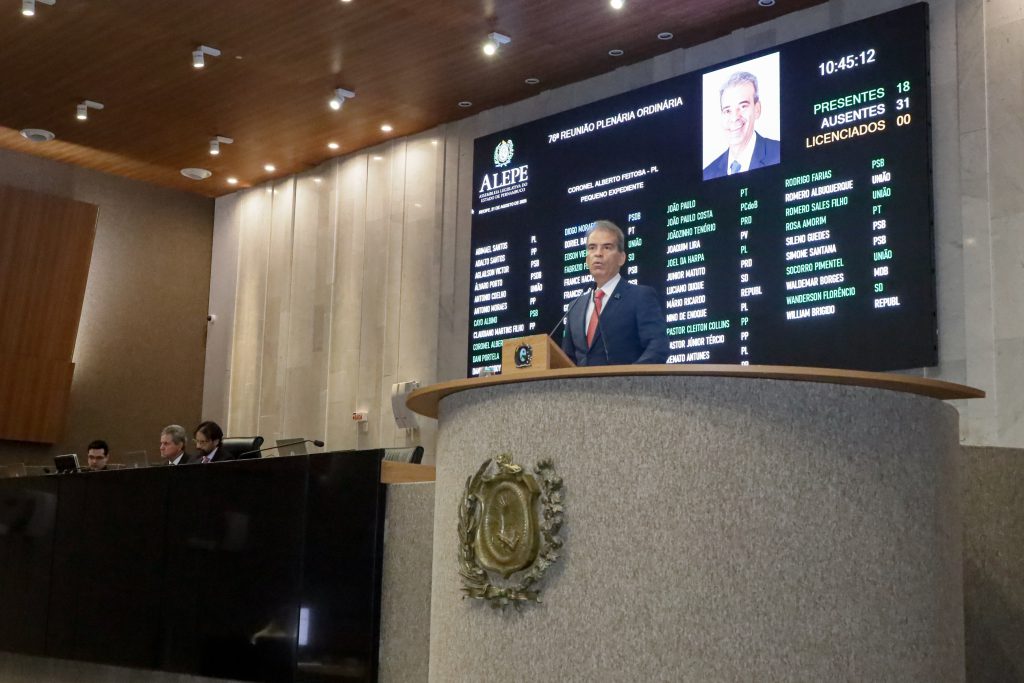 Deputado Alberto Feitosa fala na tribuna da Alepe, com telão com placar de votação e mesa diretora ao fundo