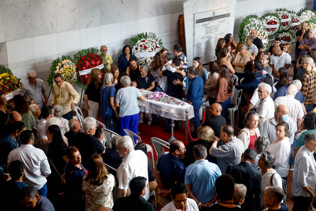 Pessoas velando o caixão do deputado Waldemar Borges no hall do Edifício Miguel Arraes. Ao fundo, coroas de flores.