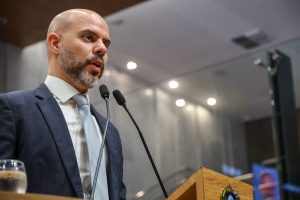 Deputado Romero Sales Filho fala na tribuna, usando terno azul marinho e gravata cinza